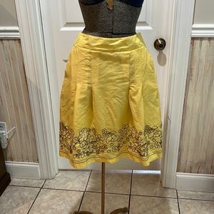 Mustard color with brown and white embroidered flowers.